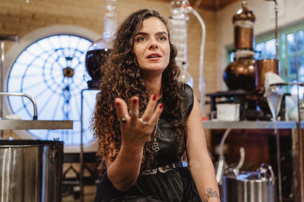 Naty Tataendy no laboratório-escola Spagiros, entre destiladores de cobre e vidrarias alquímicas
